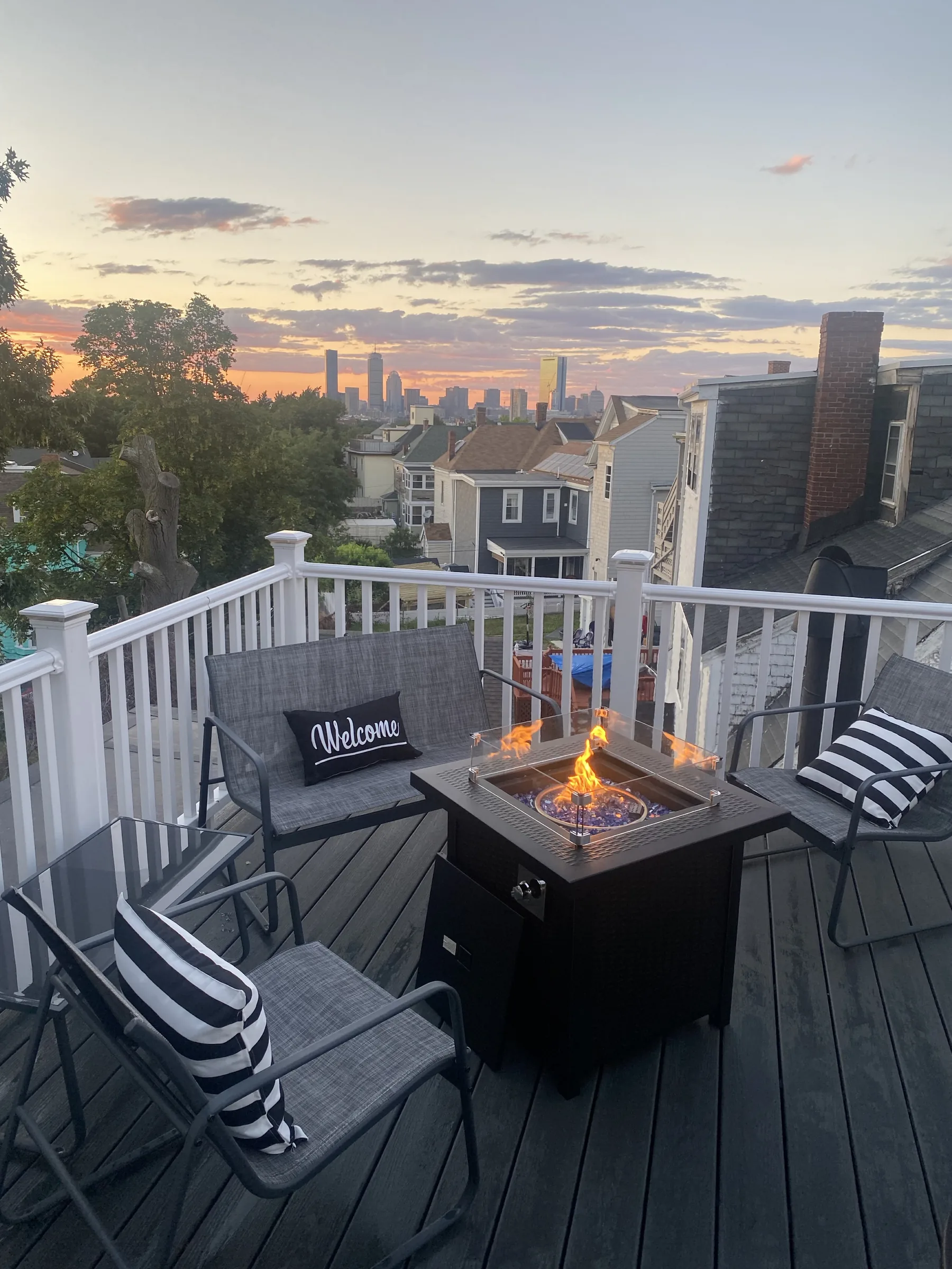 Private deck with fire pit and Boston skyline at sunset